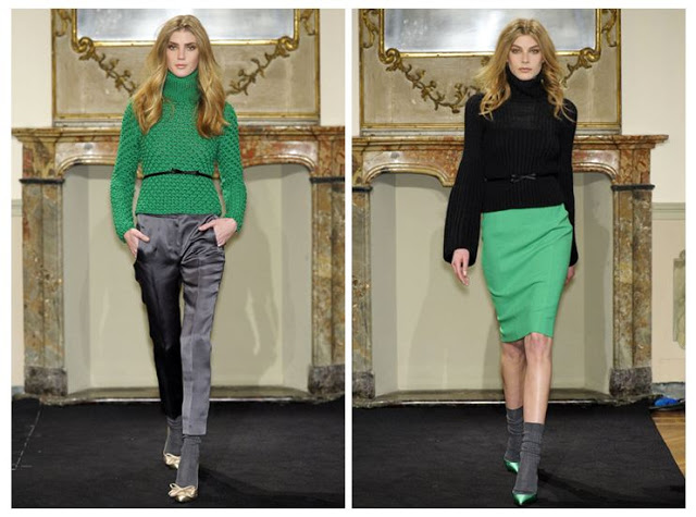 Two models from Les Copains' Fall 2011 Ready to Wear show. The model on the left is wearing a green sweater with a small belt at the waist and grey satin pants. The model on the right is wearing a black turtleneck sweater with a green skirt, green heels with grey socks