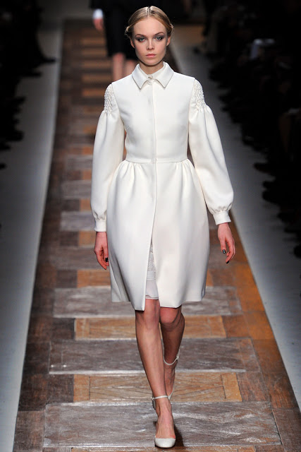 model from valentino fall 2012 runway show wearing a white winter coat over a white dress