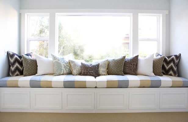 long window seat with striped olive green, blue and white cushions and patterned accent pillows