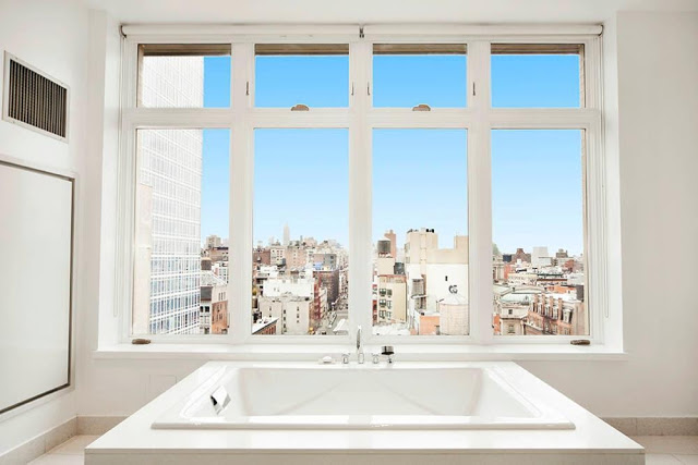 Bathtub in the bathroom of a NYC penthouse with a view of NYC