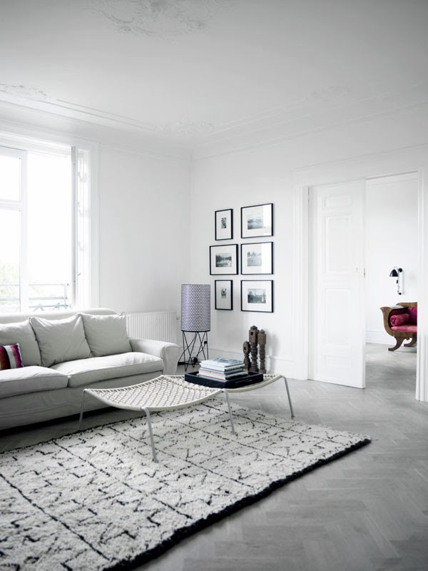 Modern grey living room with herringbone wood floors and white coffee table