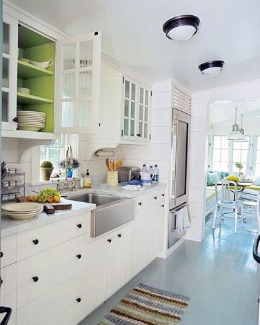 Kitchen with white beadboard cabinet drawers, a stainless farmhouse sink, lime green upper cabinet interiors and a striped rug