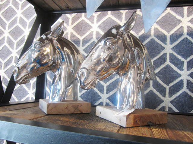 Silver horse head statues mounted on wood blocks
