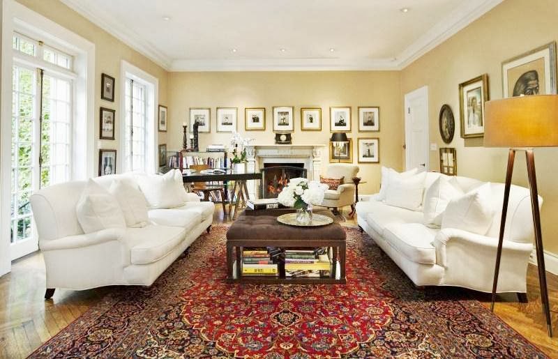 Den in NYC home with white dueling sofas, Persian rugs and herringbone wood floor