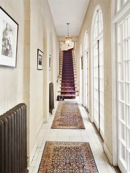 Hallway in a NYC home with french doors, white washed wood floors and Persian rugs