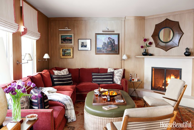 cozy family room with red sofas and a fireplace by Peter Dunham