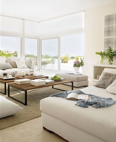 Living room with wrap around floor to ceiling sliding glass doors, dueling sofas and wood coffee table on a shag rug