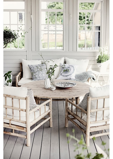 Grey front porch with grey wood furniture, stripped accent pillows and grey wood floor