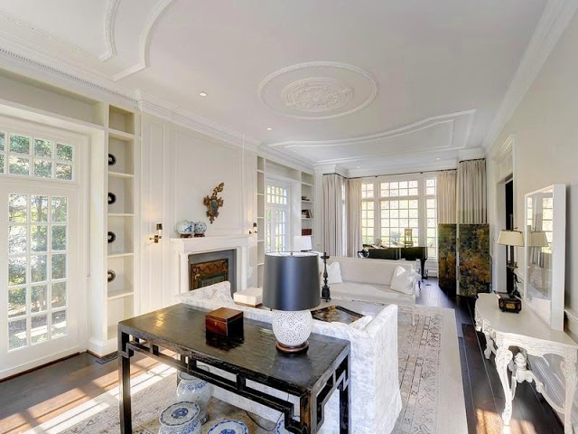 White living room with French doors and windows, wood floors, fireplace, dueling sofa and paneled ceiling