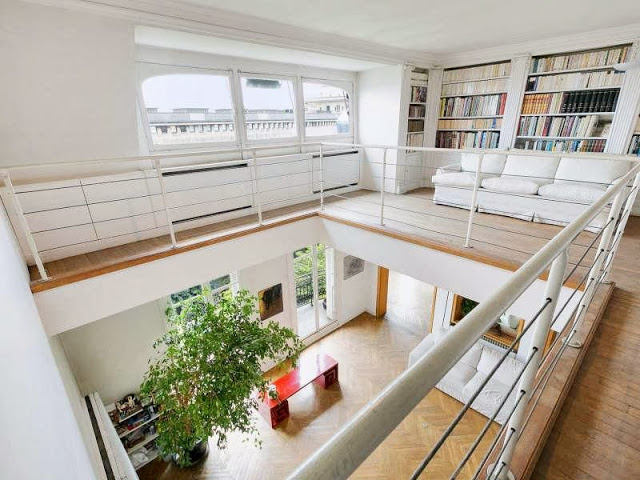 Second floor of a Paris apartment with built in bookshelves and a white sofa