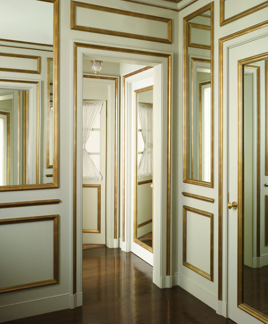  hallway of doors and mirrors with mint walls and gold decorative molding