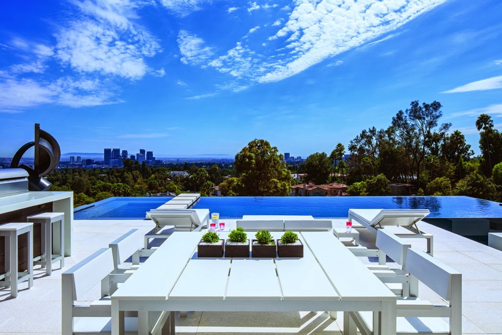 Backyard of a Beverly Hills mansion with an infinity pool and a view of Los Angeles