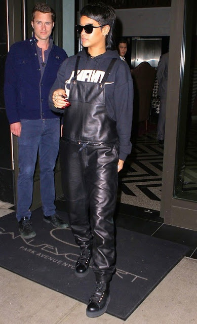 Rihanna wearing leather overalls and a navy sweater