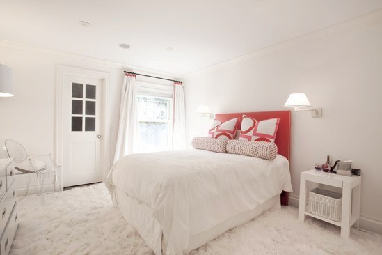 white bedroom with shag rug, nightstand, ghost Louis chair and red upholstered headboard