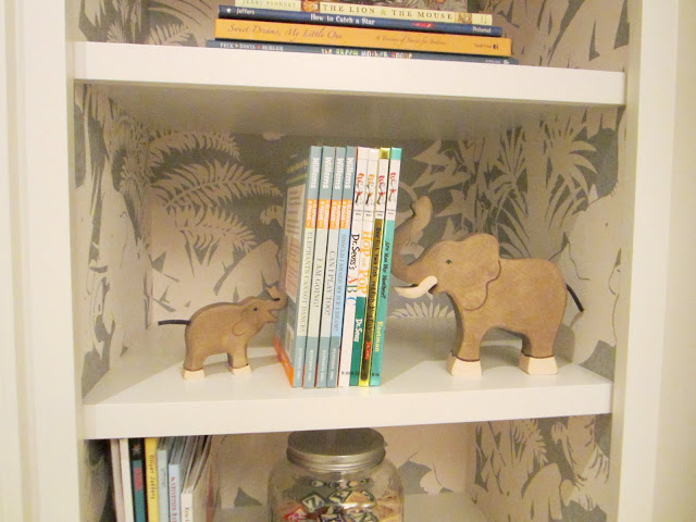 Close up of Schumacher's "Jungle Play" wall covering in the built in bookshelves and elephant bookends in the baby room in the Windsor house