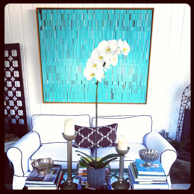 Art by Brian Wills in Coco of COCOCOZY's living room with a white sofa with brown piping