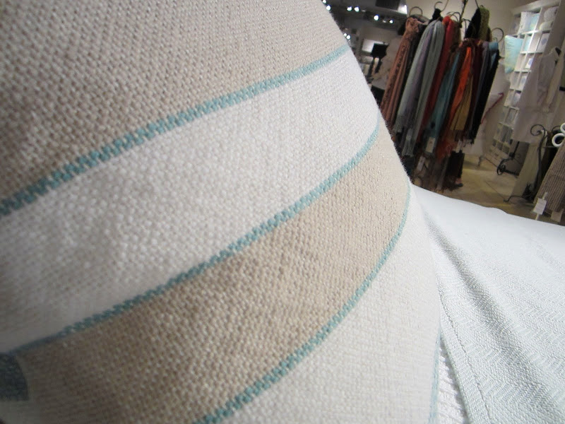Close up of one of the woven blue, white and beige striped pillows