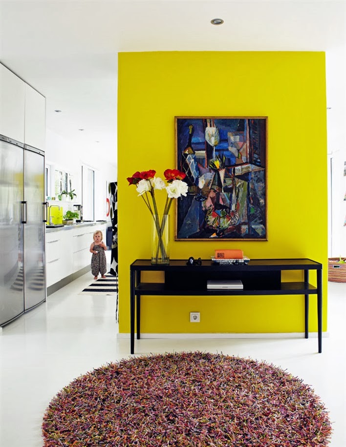 Bright yellow floating wall in a foyer of a modern home