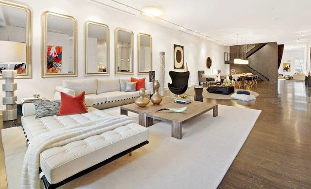 alternative view living room in a Soho Condo in New York with white sofa, gray table, decorative mirrors and orange accents