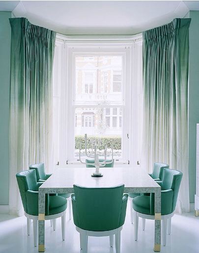 Ombre sea foam green curtains and chairs in the dining room with a large window and white candlestick holder