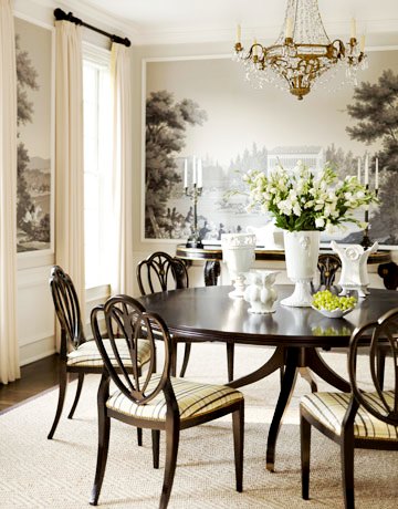 dining room with black and white pastoral wallpaper, a crystal chandelier, round dark wood table with matching chairs and a dark wood floor