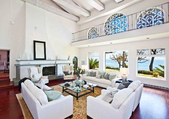 living room with exposed beams, dueling sofas, wood floors, a large area rug, a fireplace and gorgeous ocean views