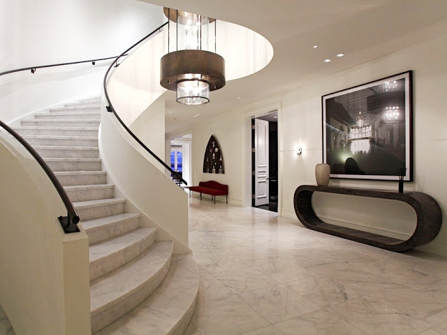 foyer with marble floors and staircase, and a chandelier light