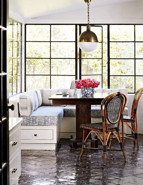 Breakfast nook with a built bench seating, a pendant light and large windows with black frames