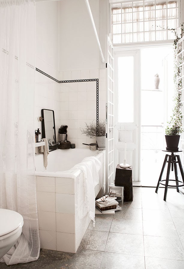 Black and white bath with black accents and french door leading to patio
