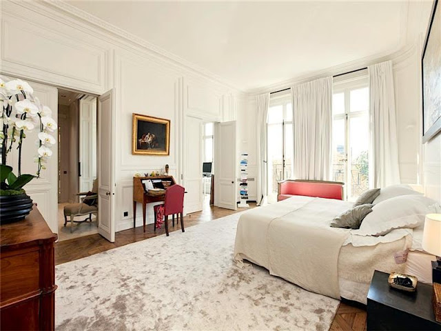 bedroom with paneled walls, french doors, tall windows, a writing desk and high ceilings