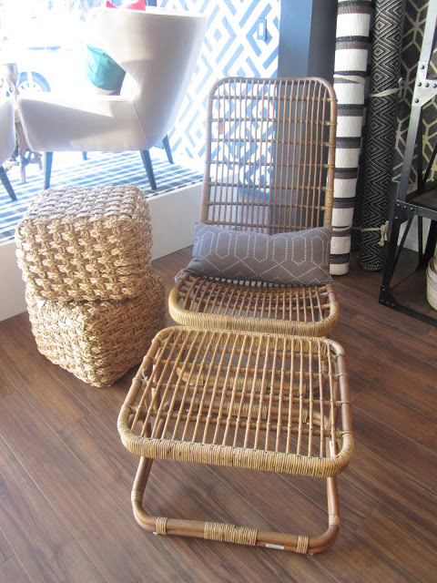 rattan lounge chair next too two wicker cubes stacked on top of each other