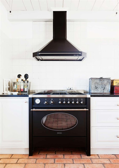 gas range in the kitchen in black with a white tile backsplash