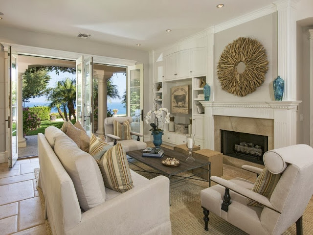 Living room in a Malibu villa with taupe furniture, branch mirror and ocean views