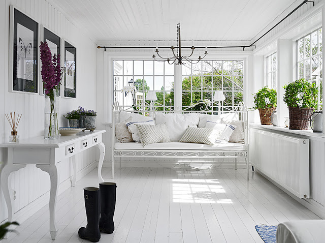 White indoor porch Swedish cottage painted wood floor white wire bench white cushions 