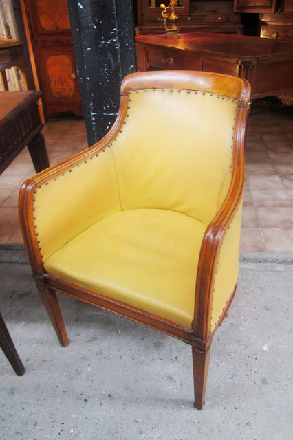 Close up of 17th century antique petite barrel side chairs upholstered in a mustard yellow leather like material
