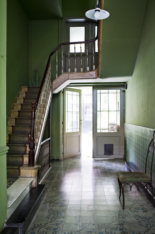 Green foyer with a staircase, tile floor, and white door