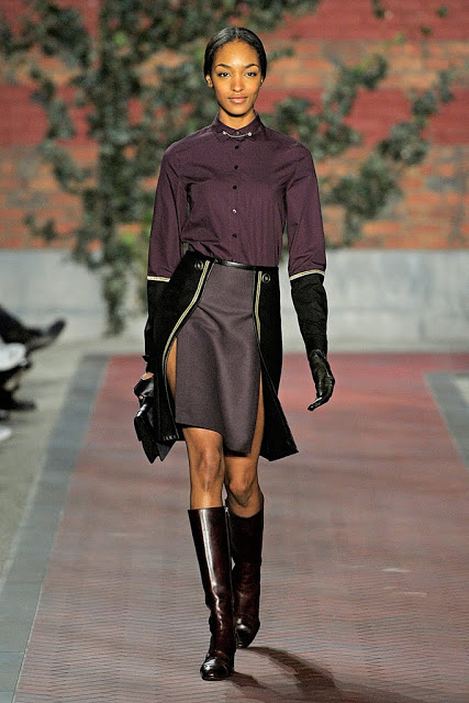 model from tommy hilfiger's fall rtw 2012 collection wearing a black, purple and gray skirt with slits and yellow piping trim and black opera gloves