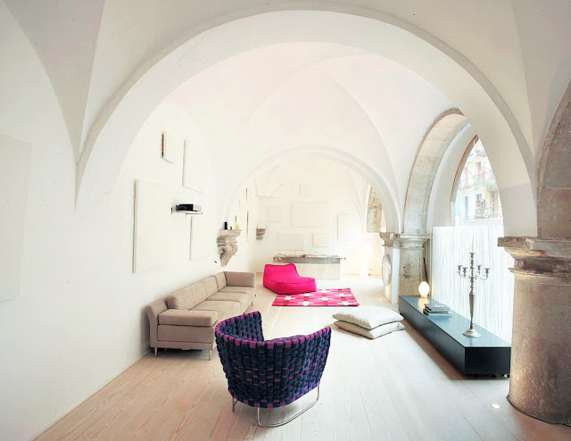 cloister in Barcelona turned into a modern living room with purple and pink accent chairs