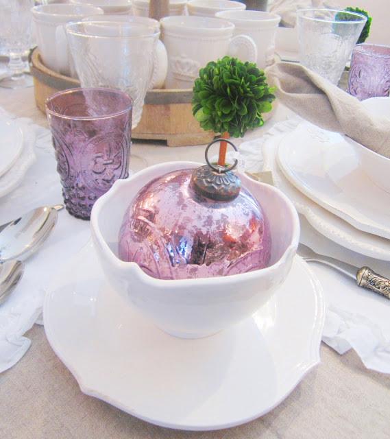 Purple metal ornament in a white ceramic mug on a matching saucer
