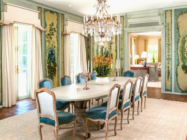 Dining room in a Palm Beach estate with crystal chandelier, custom Trompe-l'oeil painted walls, wood floor and blue velvet upholstered chairs