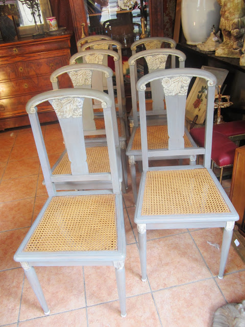 A set of 8 painted blue grey cane dining chairs with carved details on the legs