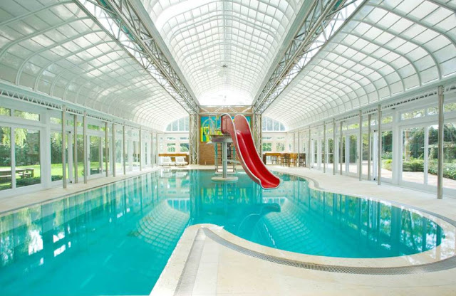 Mansion with indoor pool and a red water slide 