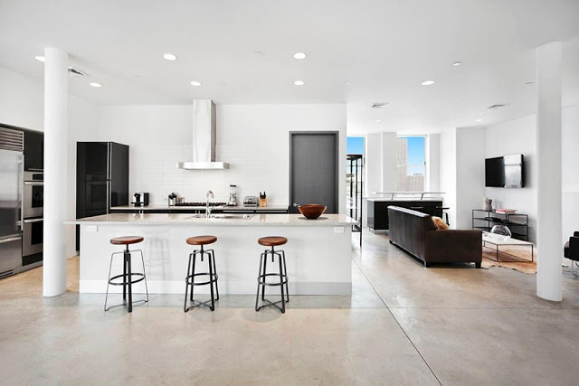Modern kitchen in a NYC Penthouse with tile floor, stainless appliances and metal barstools