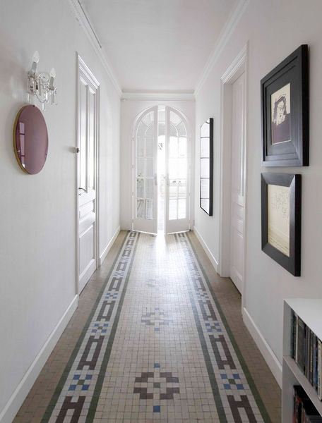 foyer in Barcelona home with mosaic tile floor, white walls with minimalist decorations and a white arched French doors