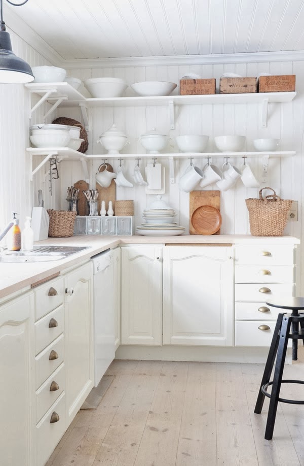White kitchen with open shelving and natural wood and woven accents