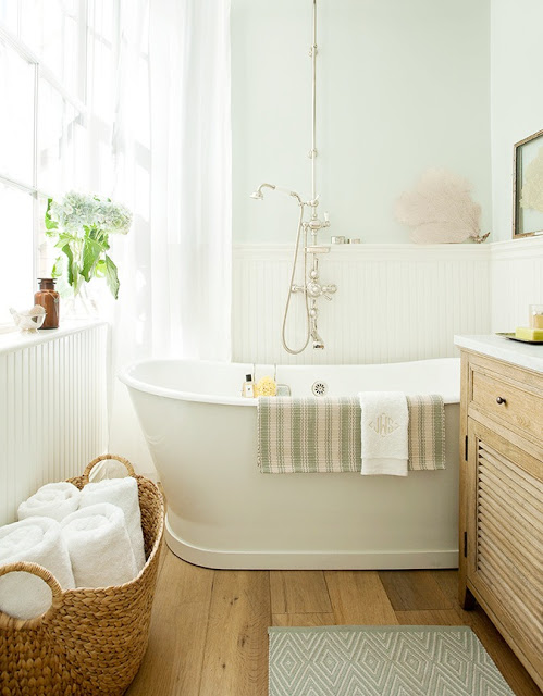 Bathroom with vintage cast iron tub, Perrin & Rowe fixtures and reclaimed white oak floors