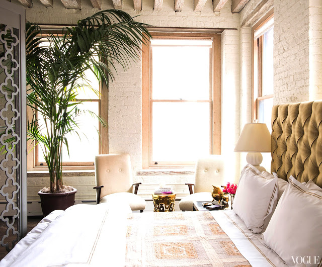 Zani Gugelmann's bedroom in her NYC loft with Boomerange chairs, a fern and white bedding