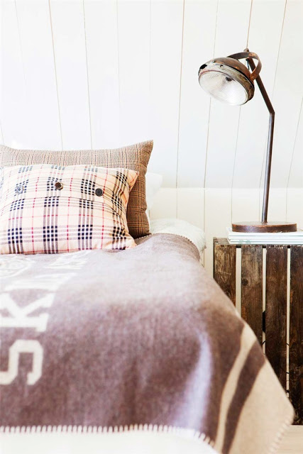 close up of plaid pillow case and wood panel container converted into a nightstand