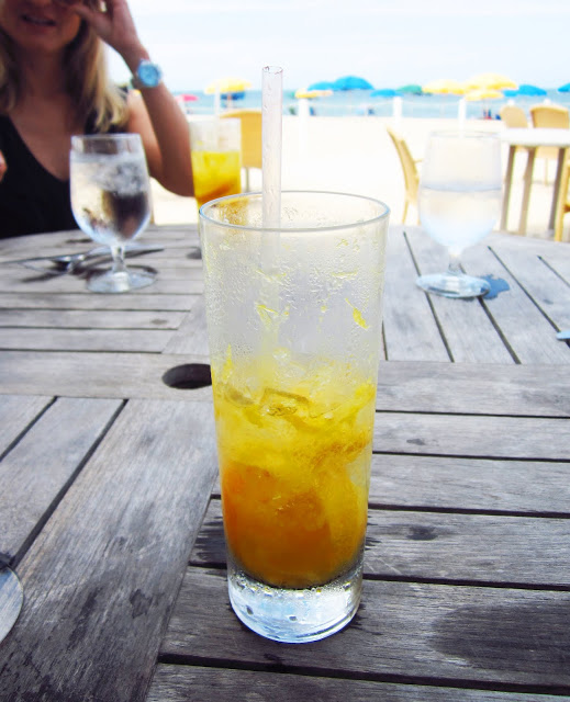 orange fizzy drink on a wood table on the beach