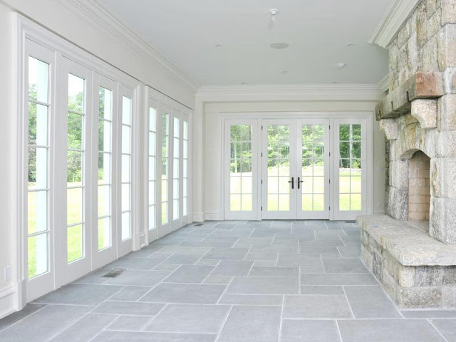 Den with french doors, stone fireplace and slate floors with a view of the backyard